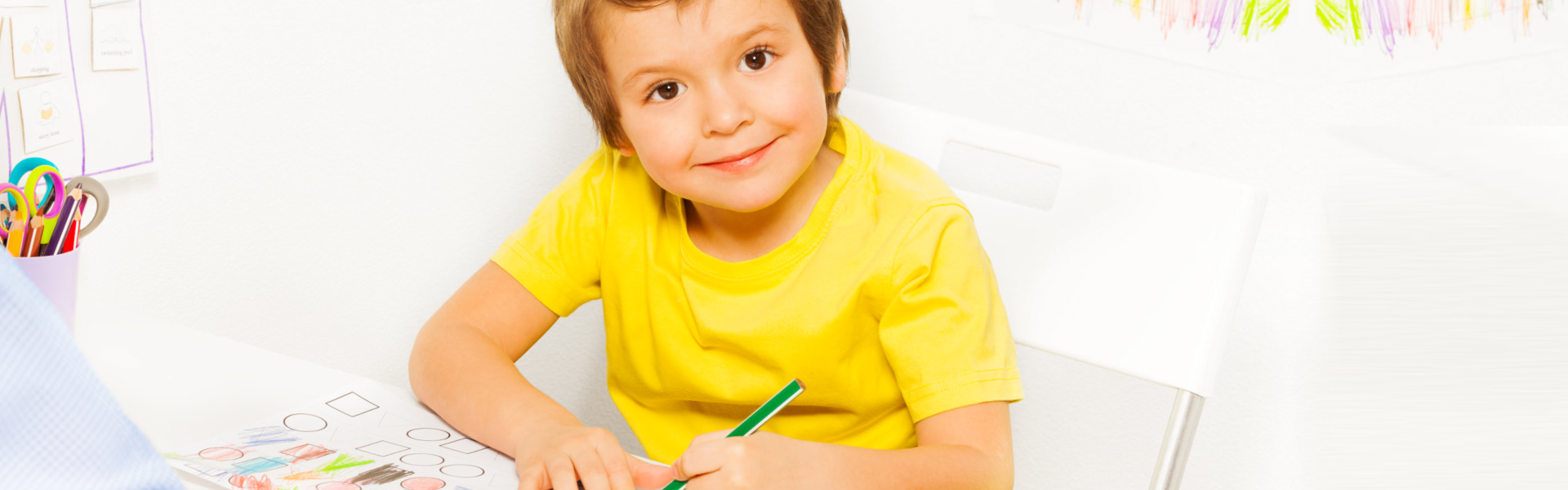 little kid smiling while writing