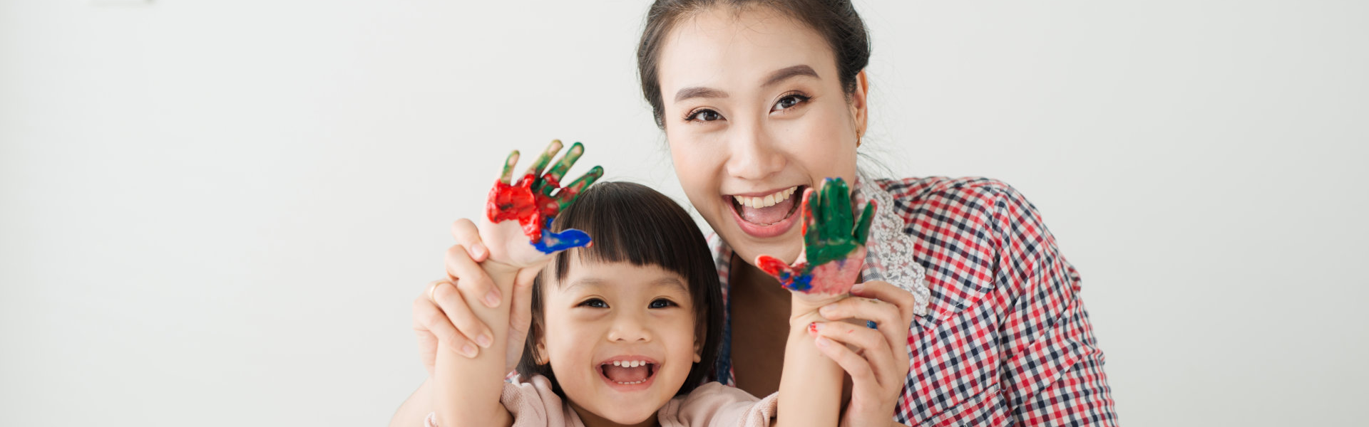 teacher and little kid with painted hands raising their hands